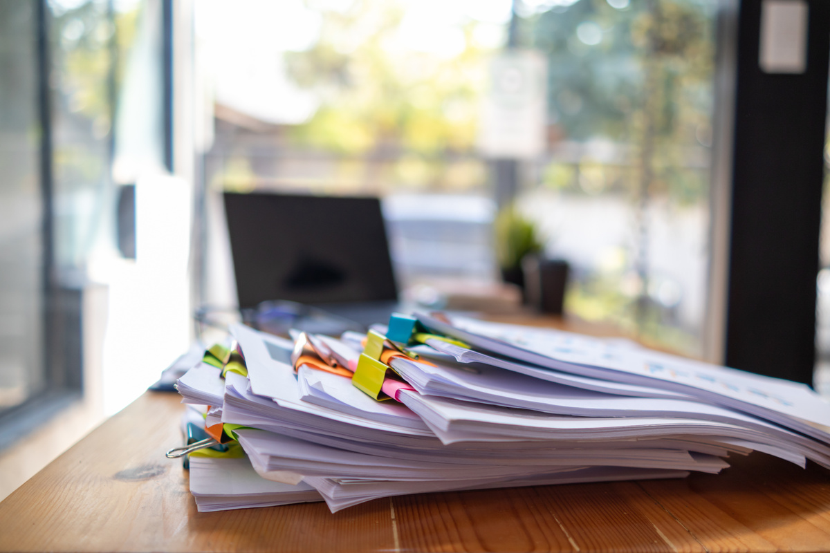 A huge stacked documents is an annual earnings summary document prepared for business people to use in attending meetings and this stacked paper is also an important document.